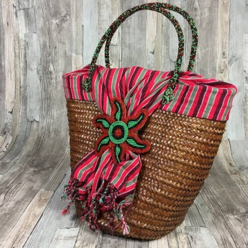 Vrolijke rieten mand met gestreepte stof in rood en geborduurde bloem